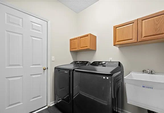 Laundry room with washer, dryer, and utility sink