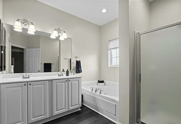 Primary bathroom with double vanity, soaking tub, and walk-in shower